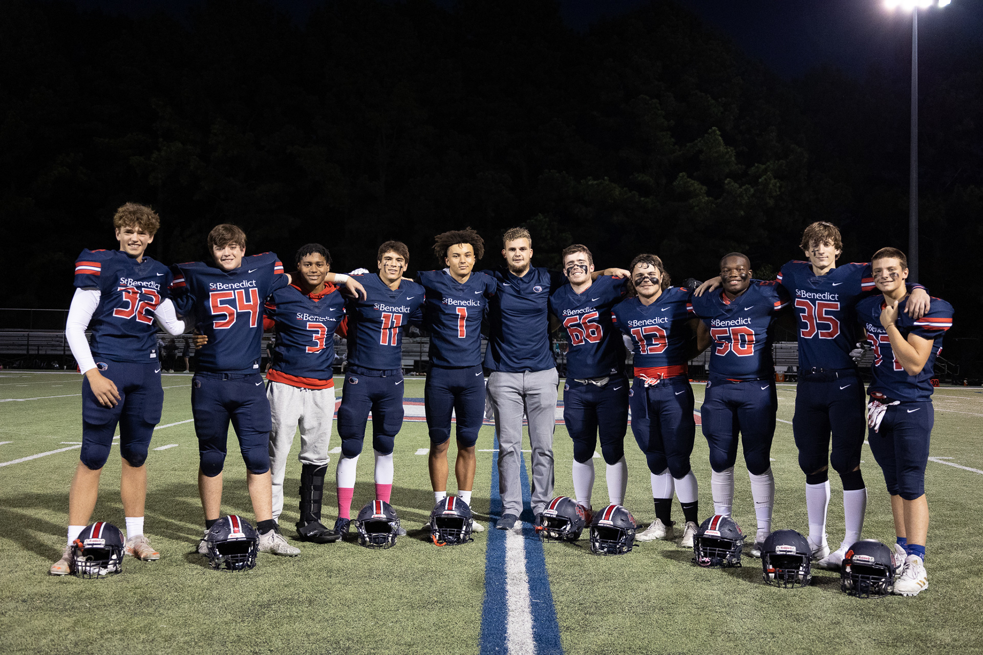 The seniors pose for a pregame photo with Coach Magnifico. (Photo by Ryan Beatty)